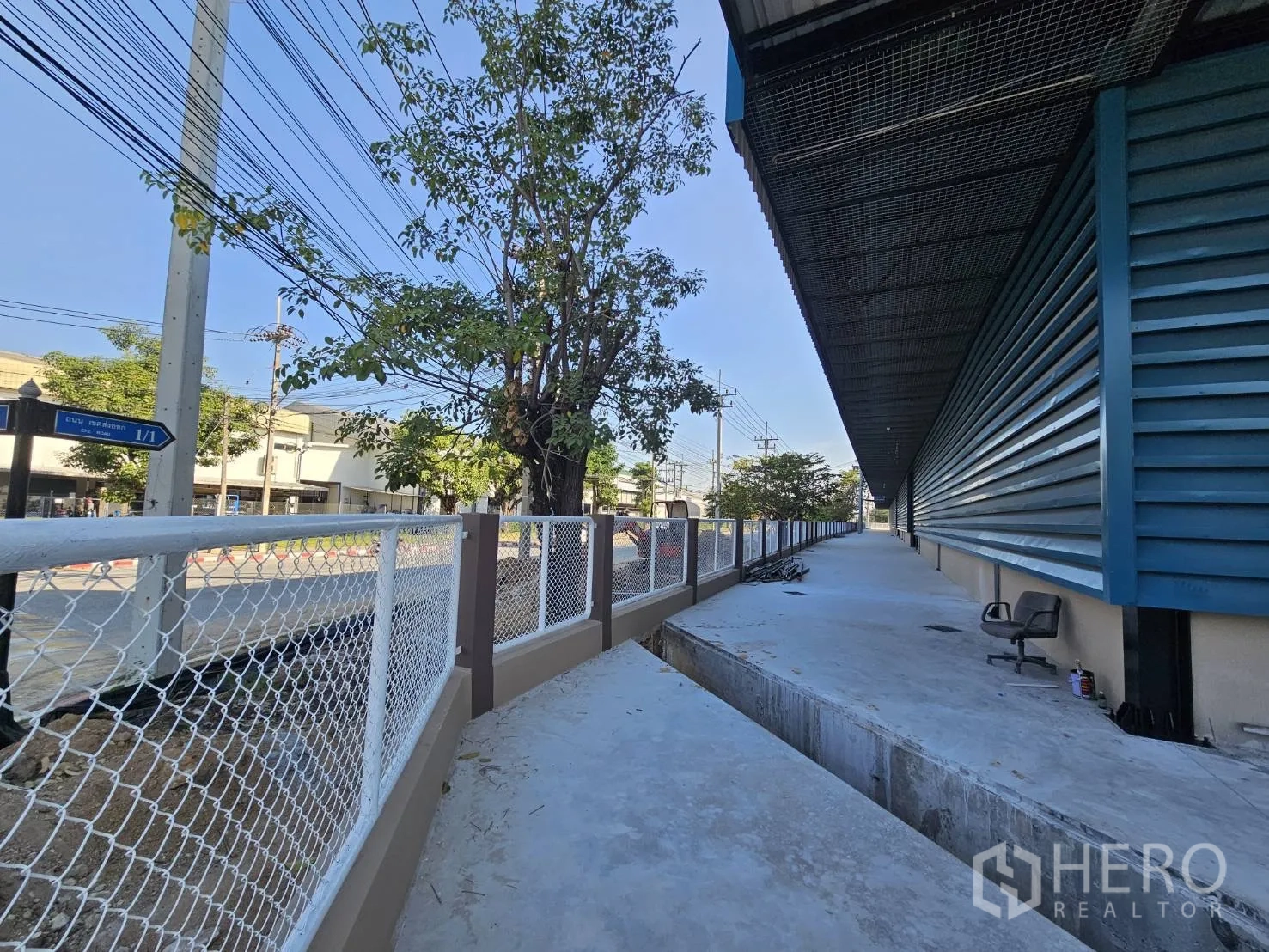 โรงงาน ให้เช่าในChon Buri - ทางเดินรอบอาคารภายนอก พร้อมรั้วตาข่ายและต้นไม้ให้ร่มเงา