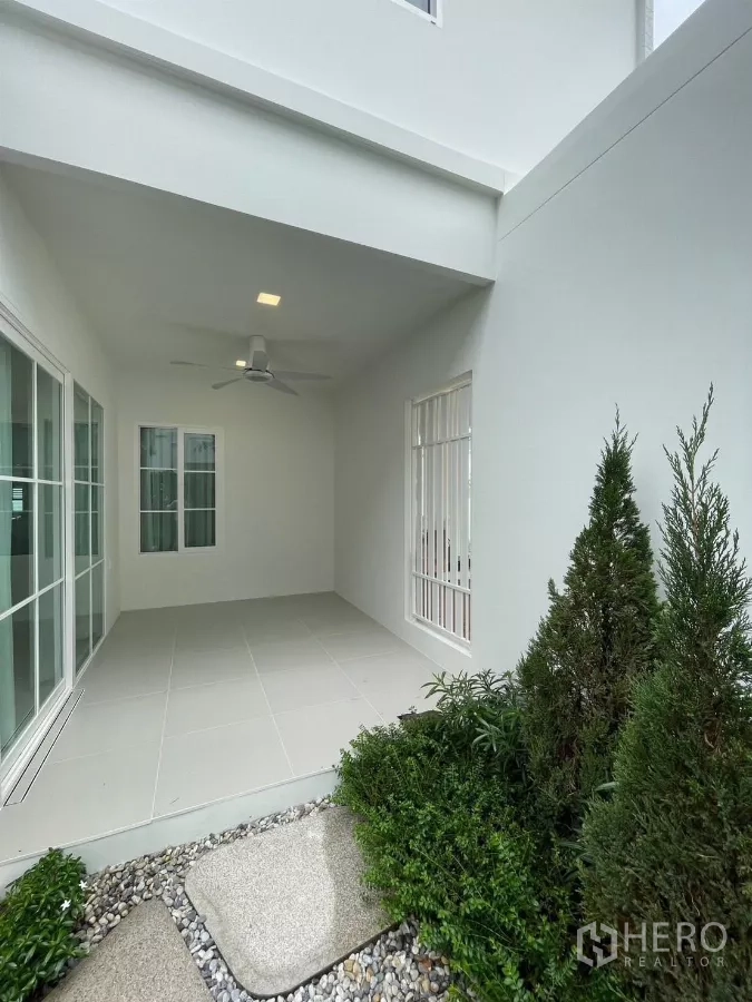 Detached House for rent in Bang Phli, Samut Prakan - Covered terrace with ceiling fan opening to a small landscaped garden.