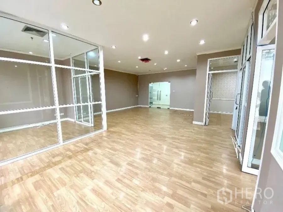 Office Space for rent in Khlong Toei, Bangkok - Bright open-plan office with wood flooring, glass-partitioned meeting room and recessed lighting.