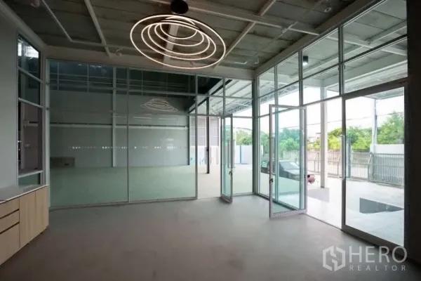 Warehouse for rent in Lat Krabang, Bangkok - Glass-front office lobby with floor-to-ceiling windows and contemporary circular lighting.