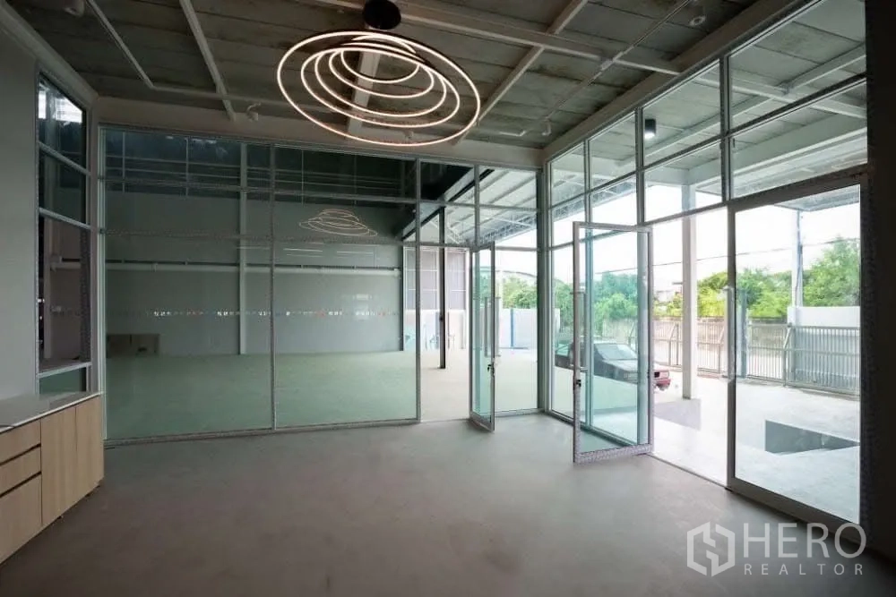 Warehouse for rent in Lat Krabang, Bangkok - Glass-front office lobby with floor-to-ceiling windows and contemporary circular lighting.