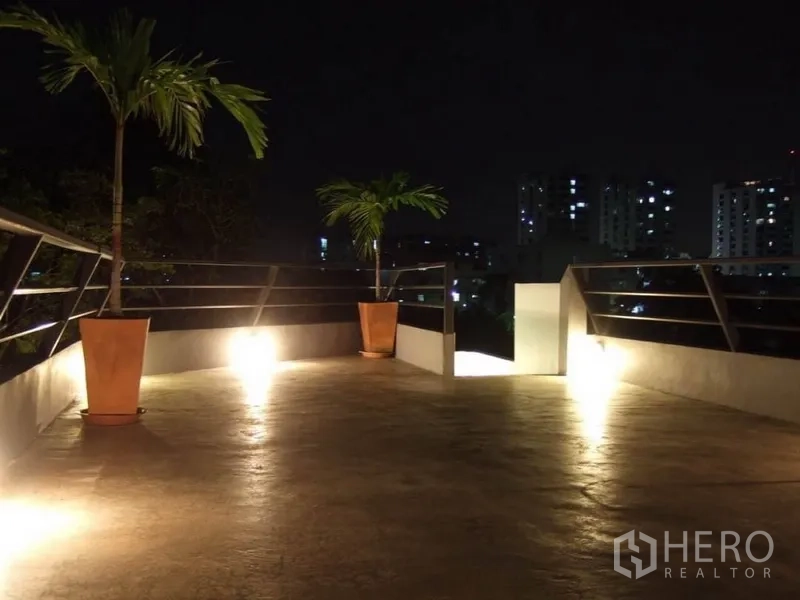 Detached House for rent in Wang Thonglang, Bangkok - Rooftop terrace at night with city skyline views and potted palms.
