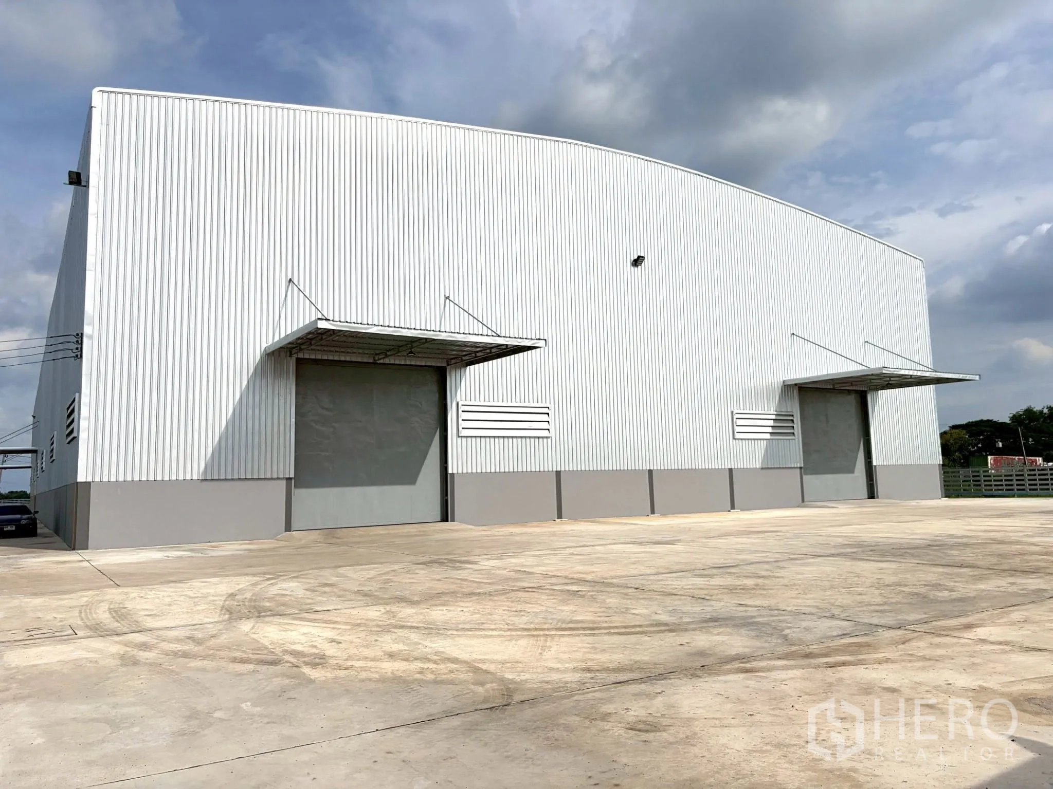 Factory for rent in Uthai, Phra Nakhon Si Ayutthaya - Front elevation of the factory with two wide loading doors under canopies and a concrete apron.