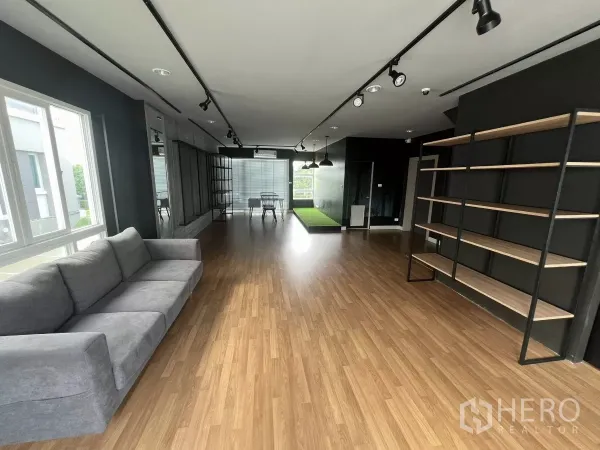 独立式住宅 出租或出售在Don Mueang, Bangkok - 开放客厅，灰色沙发、长层架与轨道照明。
