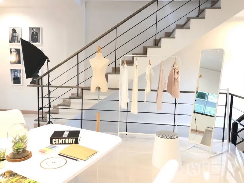 店屋 出租在Lat Phrao, Bangkok - 开放式楼层配楼梯、服装挂架与落地镜，适合作展厅或办公。