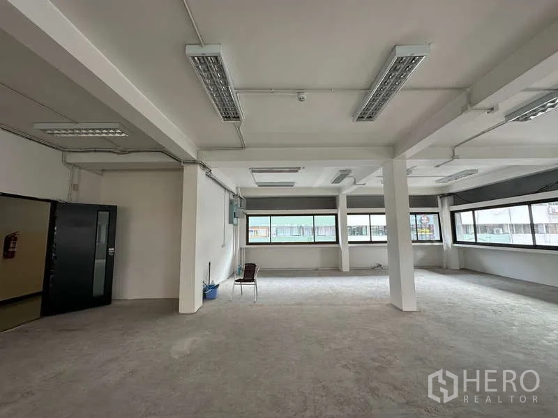 Office Space for rent in Watthana, Bangkok - Unfurnished office interior showing an open layout, wide windows, and entry door ready for fit-out.