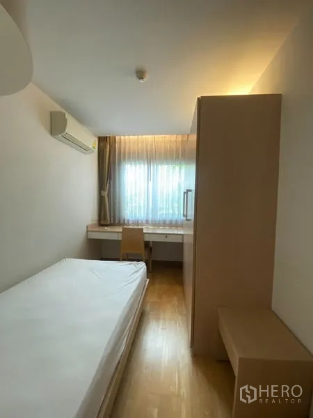 Condominium for rent or sale in Khlong Toei, Bangkok - Compact bedroom with single bed, window, study desk and wardrobe storage.