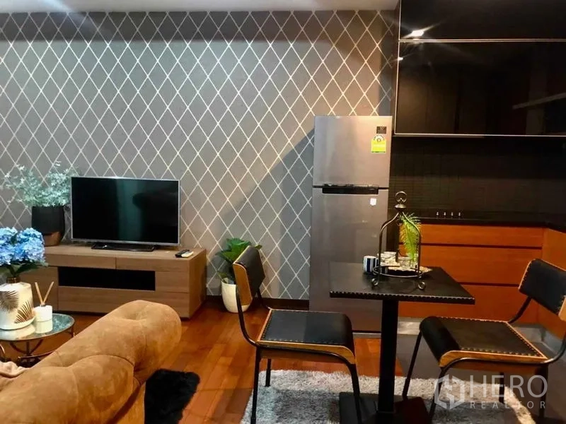 公寓 出租在Watthana, Bangkok - 开放式客餐厨布局，小餐桌、电视柜与简洁厨房。