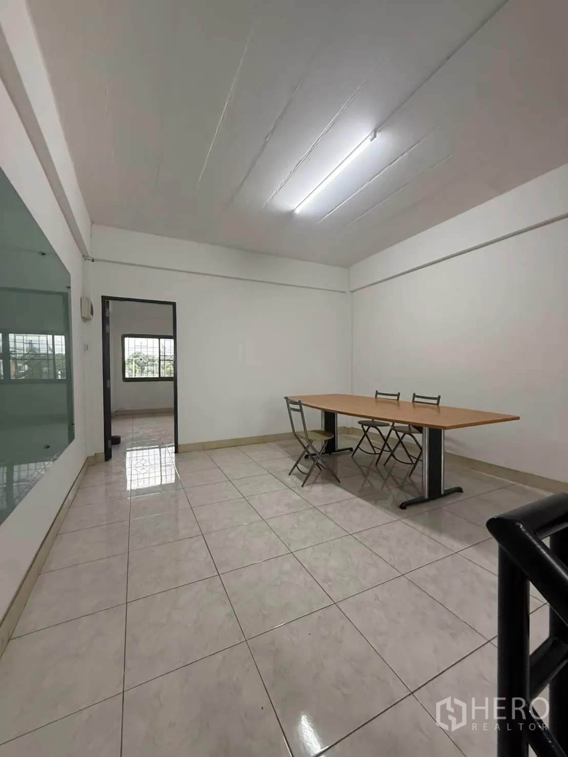 Shophouse for rent in Pak Kret, Nonthaburi - Meeting area beside the staircase with tiled floor and glass panel.