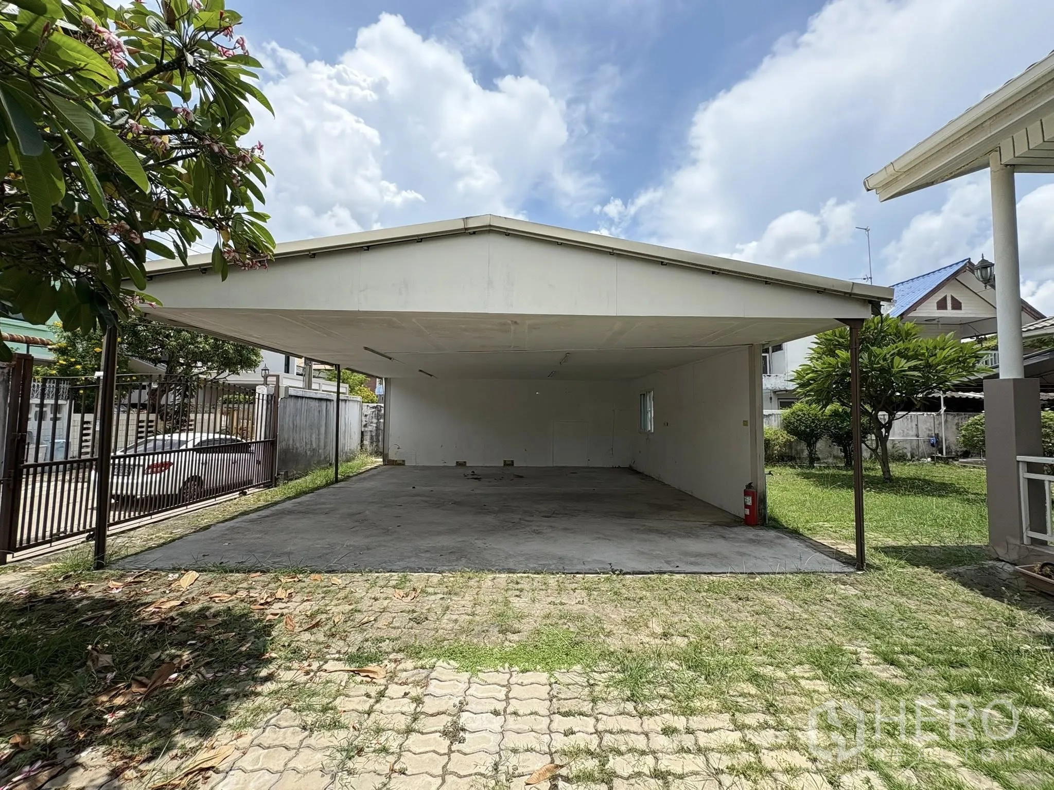 独立式住宅 出售在Phra Khanong, Bangkok - 大型有顶车棚，开敞两侧，混凝土地面与街门。