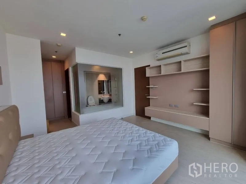公寓 出租在Watthana, Bangkok - 主卧配内置搁架与观景玻璃墙，连接套内卫浴。