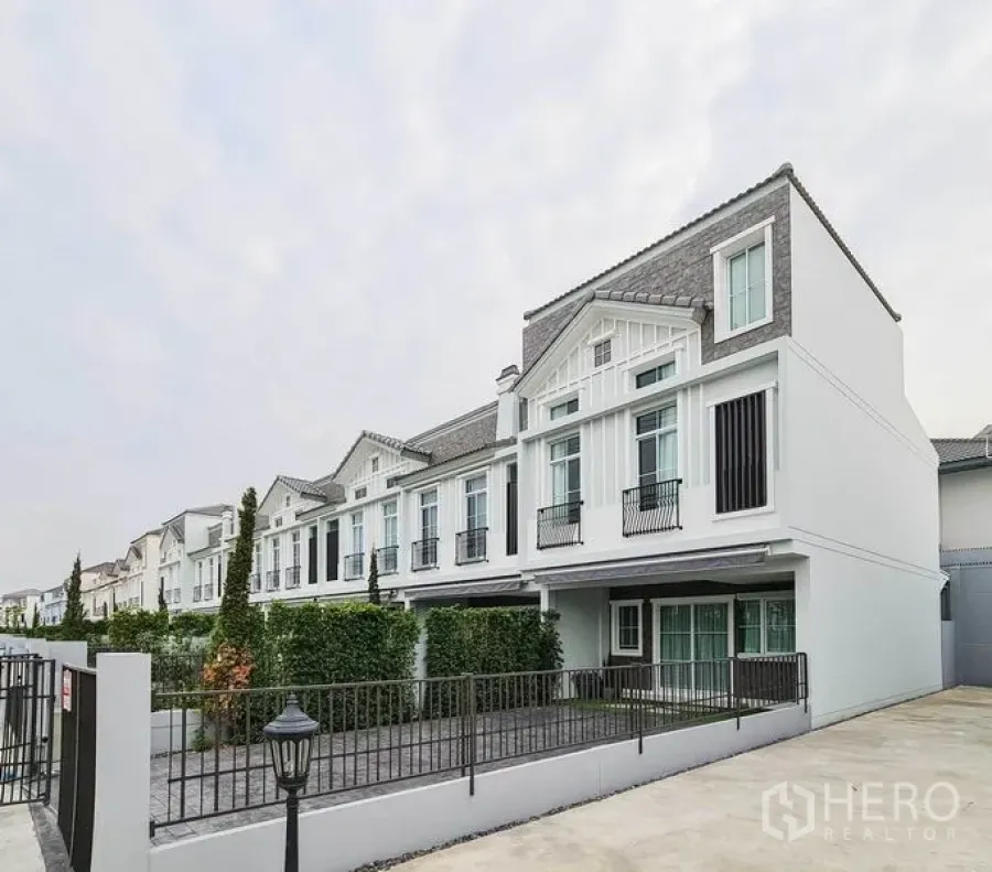 联排别墅 出租在Prawet, Bangkok - 现代联排外立面，山墙屋顶、大窗与带围栏的车道。