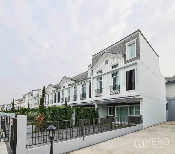 联排别墅 出租在Prawet, Bangkok - 现代联排外立面，山墙屋顶、大窗与带围栏的车道。