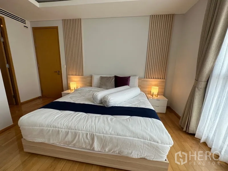 公寓 出租在Watthana, Bangkok - 特大床配床头灯，中性色调与纱帘。