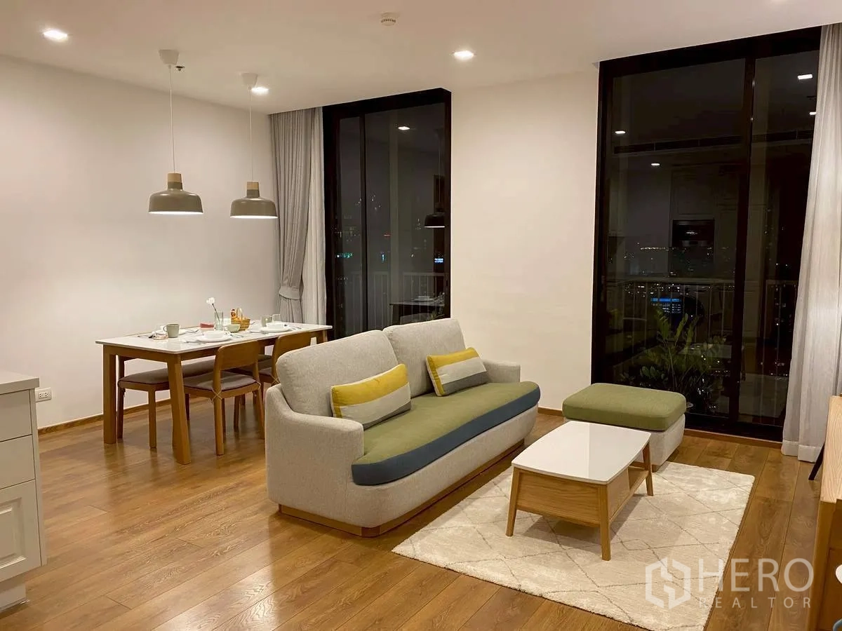 คอนโด for rent in Watthana, Bangkok - ห้องนั่งเล่นกว้างตอนกลางคืนพร้อมโต๊ะทานอาหารและประตูระเบียง