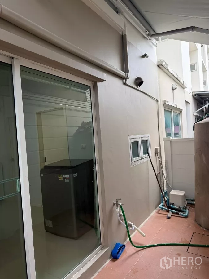 Townhouse for rent in Suan Luang, Bangkok - Rear utility terrace with sliding glass door, tap and storage space.