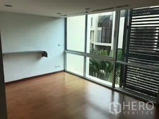 Townhouse for rent or sale in Yan Nawa, Bangkok - Bright corner room with floor-to-ceiling windows, wood floors and garden outlook in a Yan Nawa townhouse.