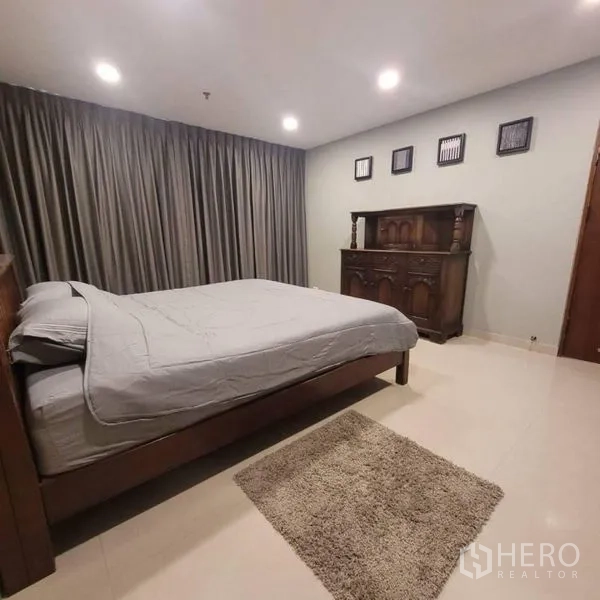 公寓 出租在Watthana, Bangkok - 第二卧室配深木色床、古典柜与厚窗帘。