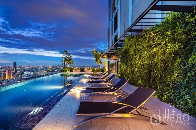 Condominium for rent in Bang Rak, Bangkok - Rooftop infinity pool with sun loungers and vertical garden overlooking the city.