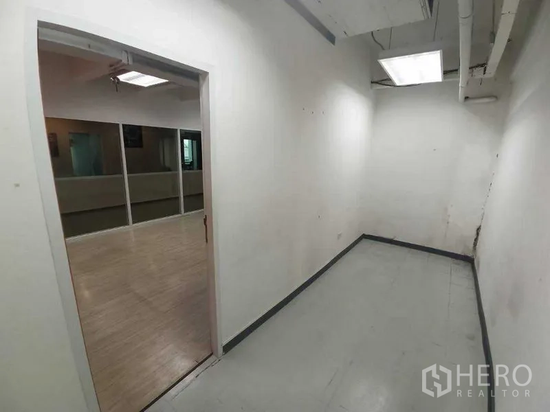 Office Space for rent in Ratchathewi, Bangkok - Narrow utility or storage room with white walls, ceiling ducts and fluorescent light.