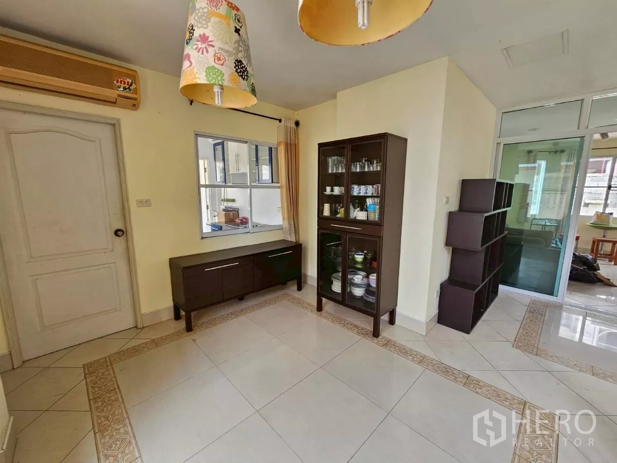 Detached House for rent or sale in Bang Lamung, Chon Buri - Dining nook with pass-through window to the kitchen and storage units.
