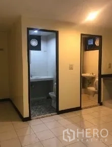 Office Space for rent in Bang Rak, Bangkok - Entrance to the office bathroom and utility area with tiled flooring and compact fixtures.