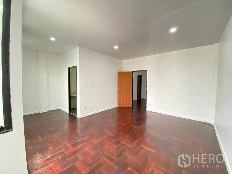 带办公室的家 出租或出售在Suan Luang, Bangkok - 卧室/办公室，木地板、白墙，带套卫入口。