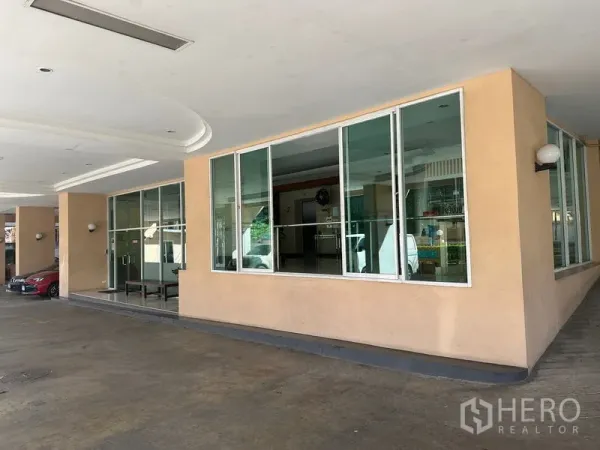 Office Space for sale - Covered driveway and glass-fronted lobby of an office building in Bangkok.