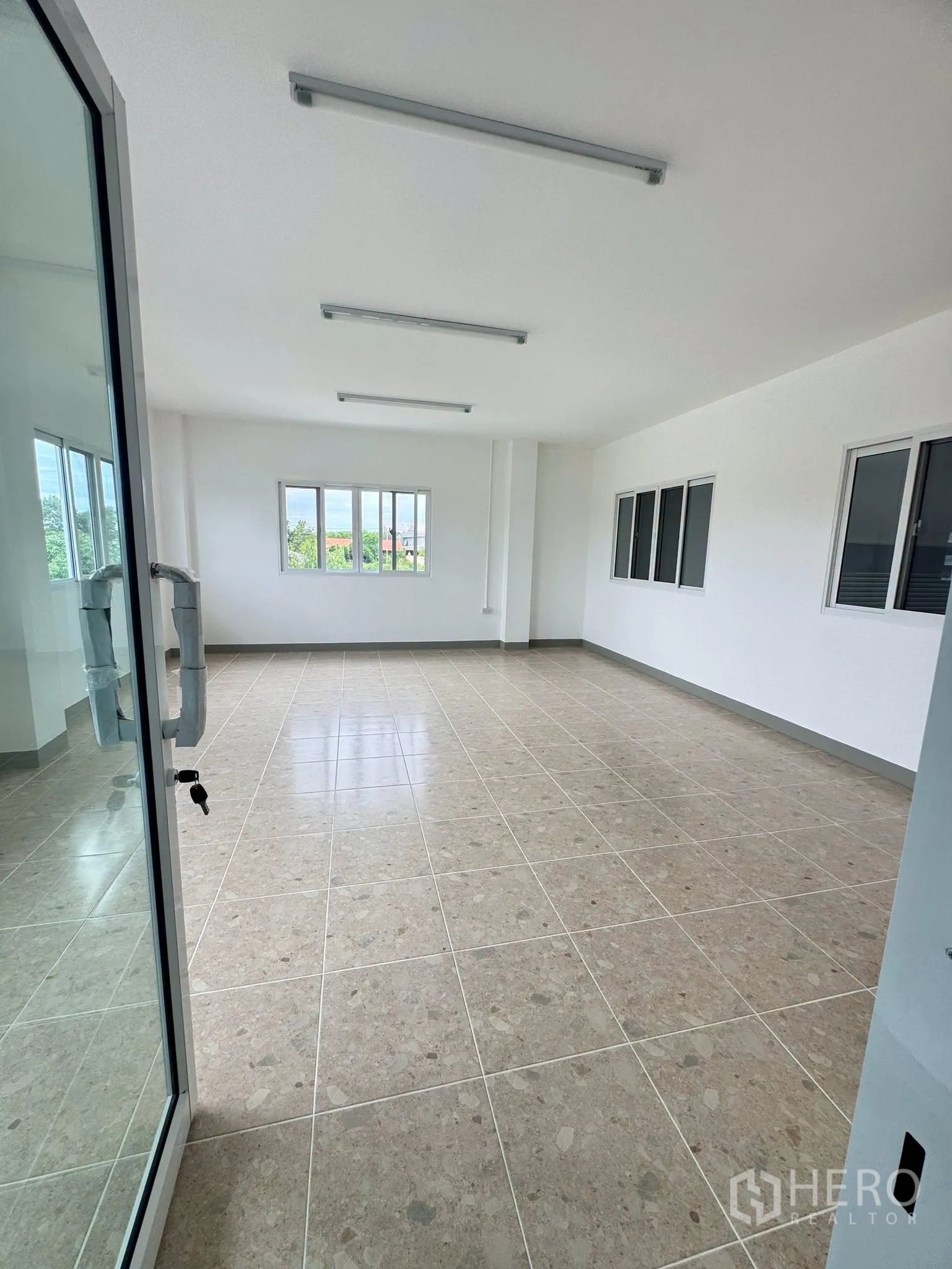 Warehouse for rent in Bang Bo, Samut Prakan - Spacious upstairs office with tiled flooring and multiple windows.