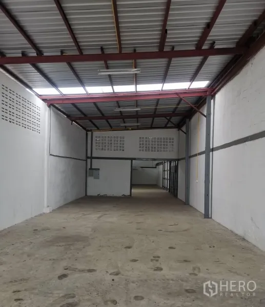 Warehouse for rent in Suan Luang, Bangkok - Long warehouse bay with steel trusses, ventilation blocks and a rear utility area.