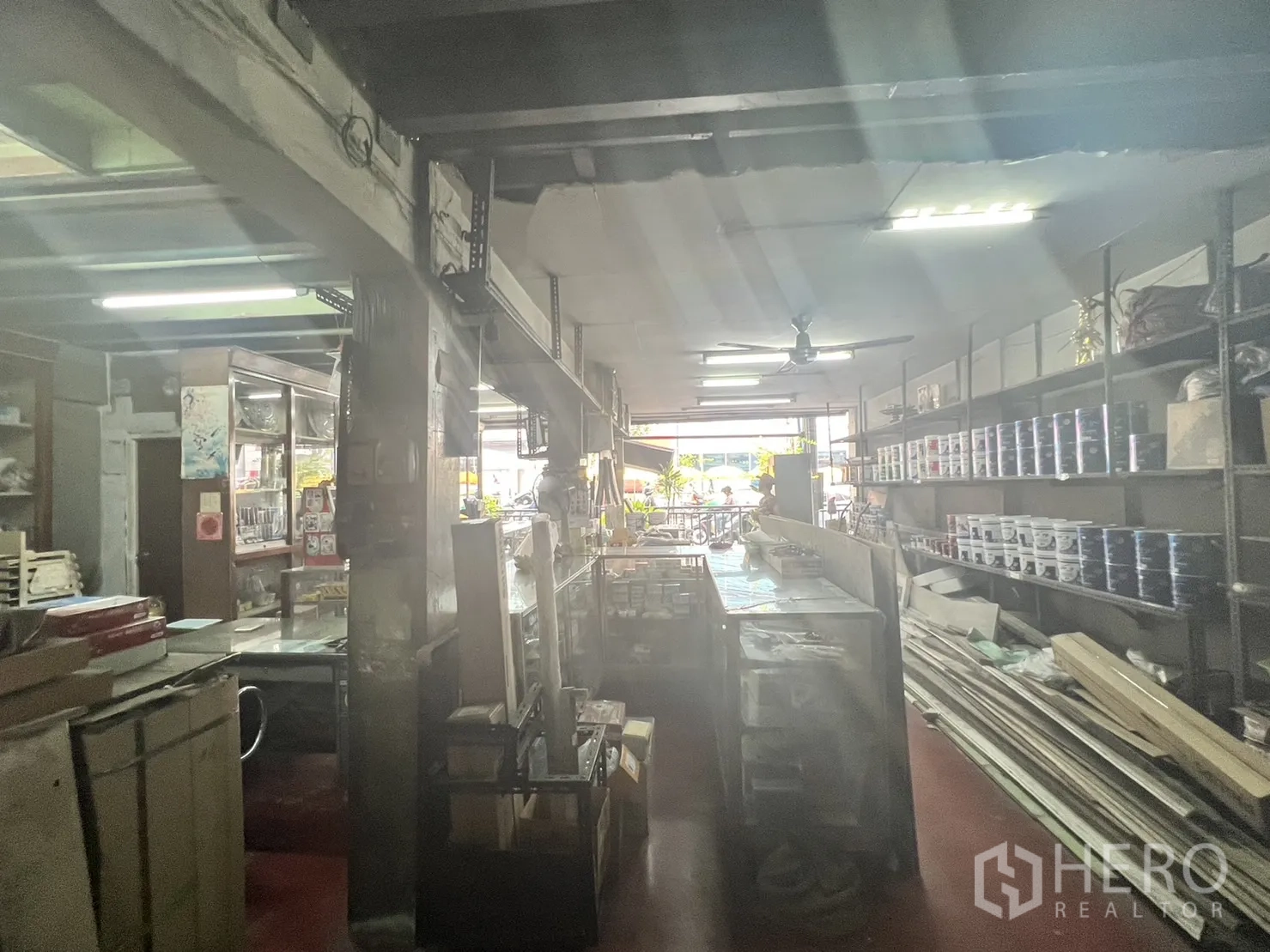 Retail Space for rent in Watthana, Bangkok - Bright view toward the shopfront with sales counter and shelving along both sides.