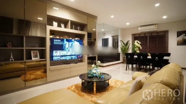 Detached House for rent or sale in Bang Phli, Samut Prakan - Open-plan living room with built-in TV wall, leather sofa and recessed ceiling lights.