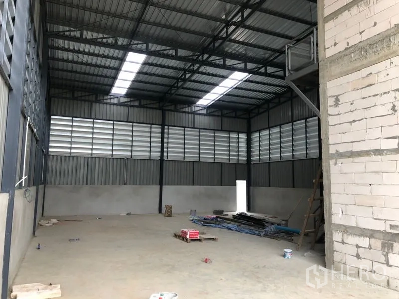 Warehouse for rent in Lam Luk Ka, Pathum Thani - Empty warehouse bay with skylight roof strips and ventilation louvers.