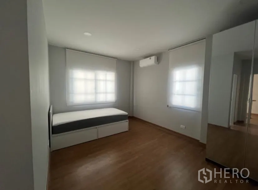 独栋房屋 for rent in Bang Phli, Samut Prakan - 简约次卧，单人床，空调，双窗采光，木地板与衣柜镜面。