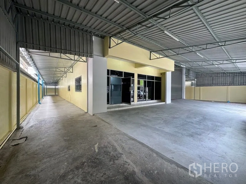 Factory for rent in Pathum Thani - Canopied entrance with glass-front office beside the loading area.