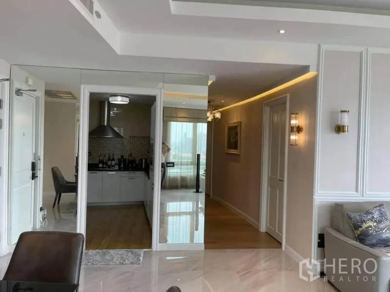 公寓 出售在Pathum Wan, Bangkok - 入口走廊设镜面墙，可见独立现代厨房与抽油烟机。