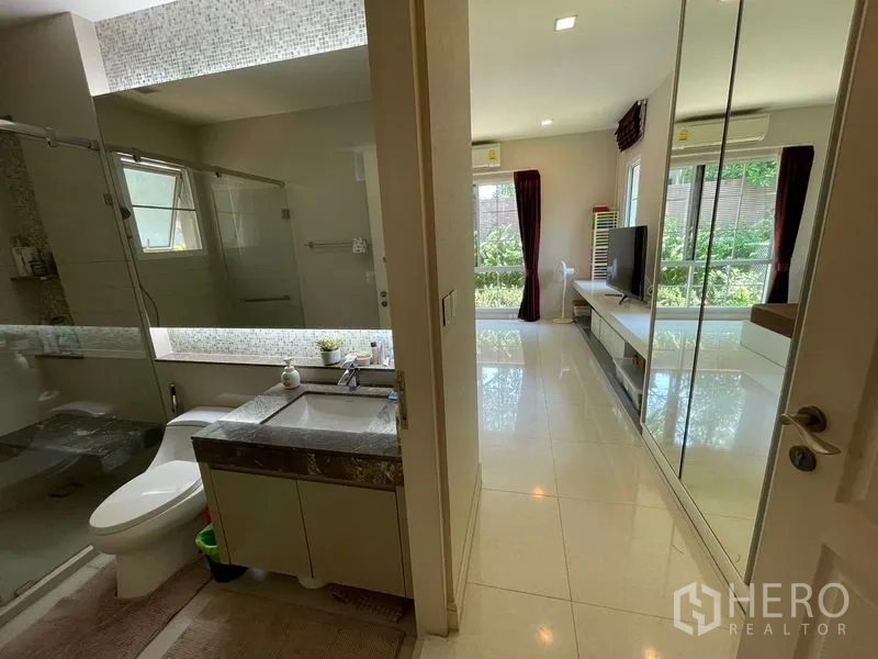 Detached House for rent in Bang Phli, Samut Prakan - Ensuite bathroom with glass shower and vanity opening to mirrored wardrobes.