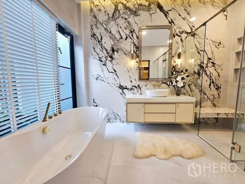 Detached House for rent or sale in Saphan Sung, Bangkok - Luxury bathroom with freestanding tub, marble feature wall, glass shower and vanity.