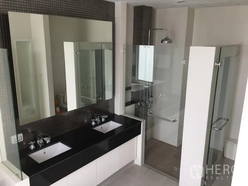 联排别墅 出售在Huai Khwang, Bangkok - 浴室设双洗手台、玻璃淋浴间与现代洁具。