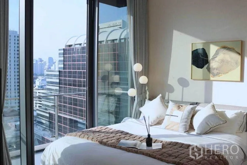 公寓 出租在Watthana, Bangkok - 床边落地窗与阳台近景，尽览都市风光。