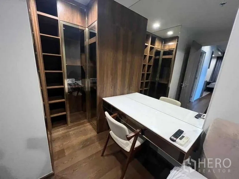 公寓 出租在Khlong Toei, Bangkok - 步入式衣帽间，玻璃柜与长梳妆台和座椅。