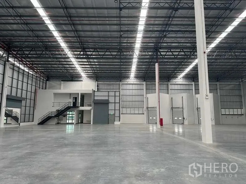Warehouse for rent in Bang Phli, Samut Prakan - Row of dock-high doors and mezzanine offices along the warehouse wall.