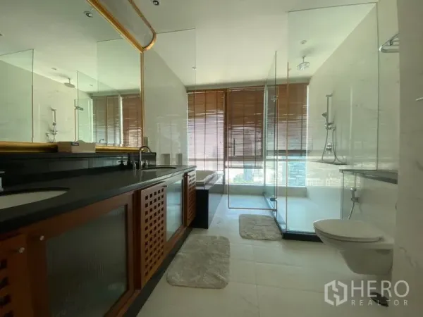 Condominium for rent in Sathon, Bangkok - Modern bathroom with double vanity, glass-enclosed shower and city-view windows with wooden blinds.