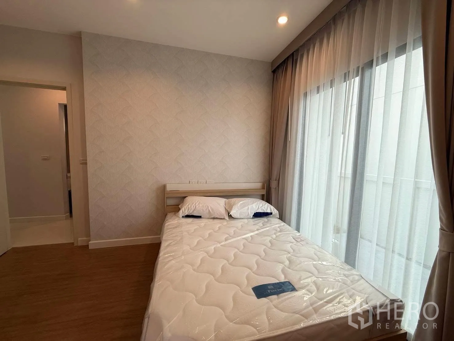 独栋房屋 for rent in Bang Phli, Samut Prakan - 温馨卧室，双人床、纹理墙纸与落地薄纱窗帘。