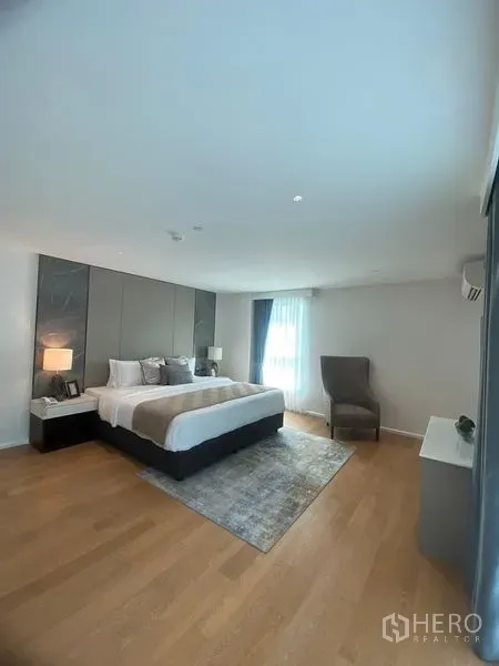 公寓 出租在Watthana, Bangkok - 宽敞主卧，木地板、特大床与大窗。