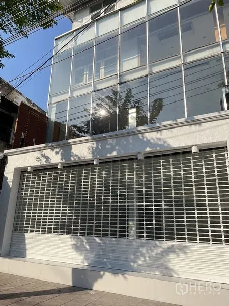 店屋 出租在Dusit, Bangkok - 多层商铺立面，大面积玻璃与一层金属卷闸门，临街展示效果强。