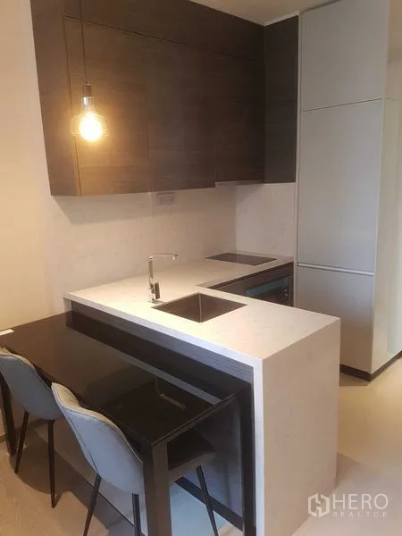 公寓 出租在Watthana, Bangkok - 紧凑厨房，石质台面岛台、水槽、电磁炉与内嵌橱柜。