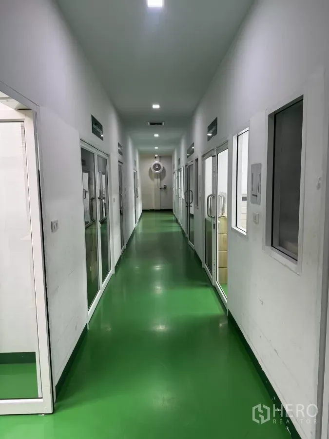 工厂 出售在Lam Luk Ka, Pathum Thani - 对称走廊，绿色环氧地坪，两侧多间玻璃门房间。