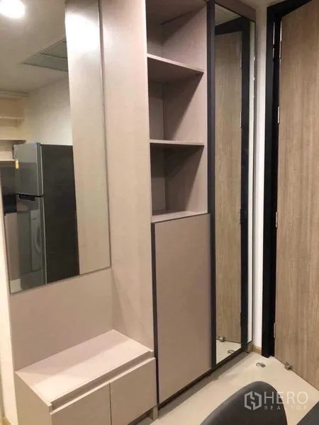 Condominium for rent in Khlong Toei, Bangkok - Entry corridor featuring built-in shoe cabinet, open shelves, and full-height mirror.