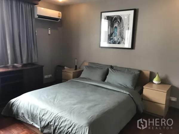 公寓 出租在Watthana, Bangkok - 主卧配双人床、床头柜与灰色床品，墙上装饰画。